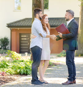 Property agent talking to a young adult couple about investing in a property.