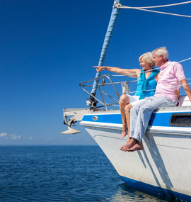 Older retired couple sitting on a boat.